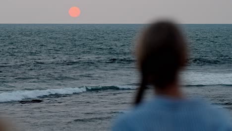 a serene moment in galle, sri lanka, as a woman gazes at the vast ocean during a breathtaking sunset.