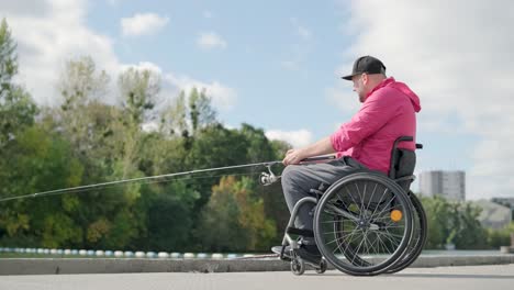 person with a physical disability who uses wheelchair fishing from fishing pier