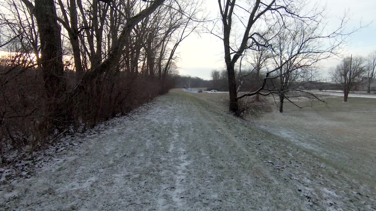 작은 눈으로 덮인 잔디 위를 낮게 날고 있는 공중