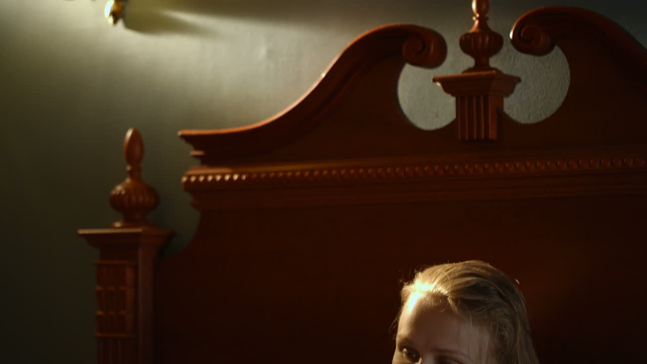 책 을 들고 침대 에 누워 있는 어머니 와 아들