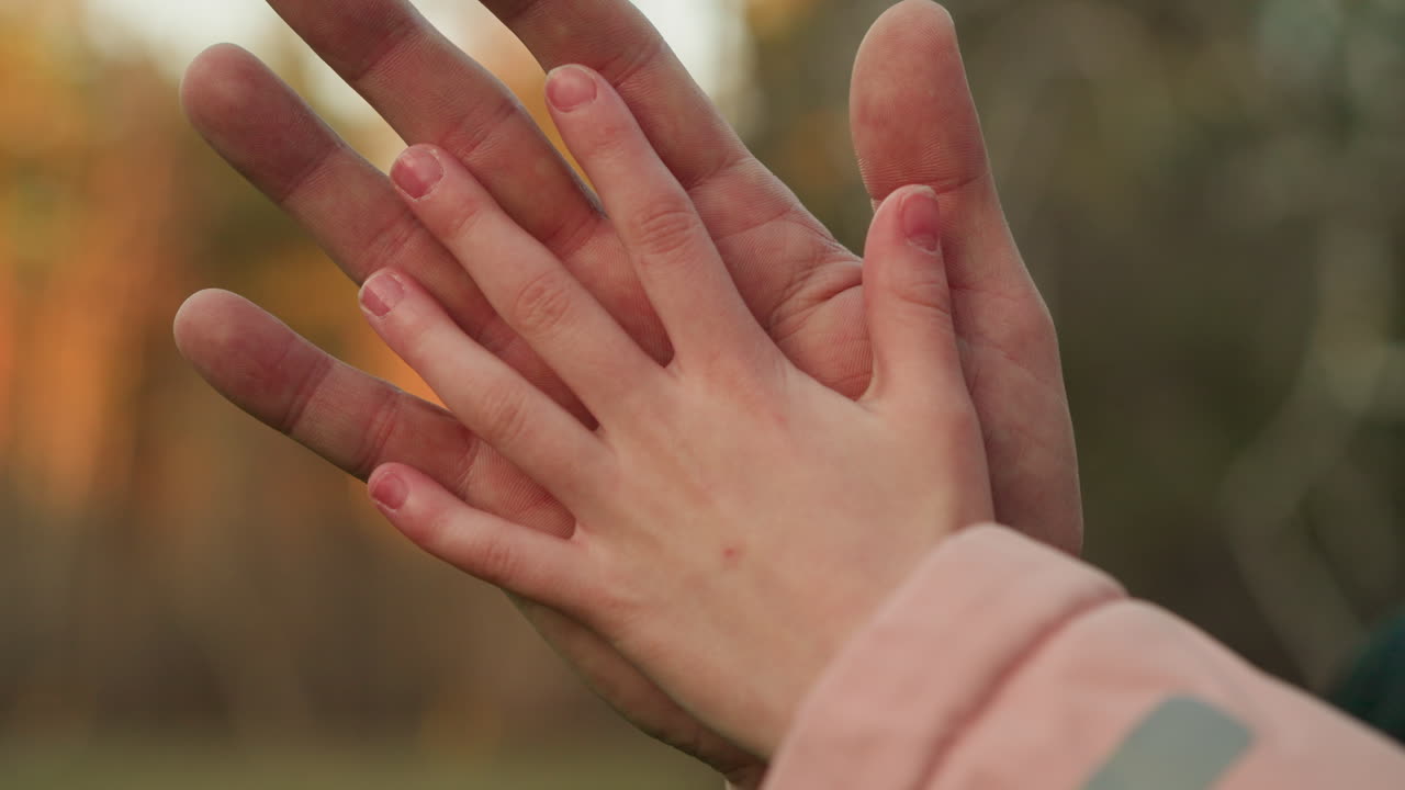 una toma de primer plano de una mano adulta puesta suavemente en la mano de un niño, simbolizando cuidado, protección y conexión. la imagen captura un tierno momento de calor y afecto