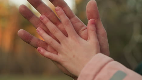 a close-up shot of an adult hand gently placed on a child s hand, symbolizing care, protection, and connection. the image captures a tender moment of warmth and affection