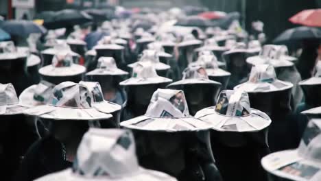 people in a protest march wearing newspaper hats