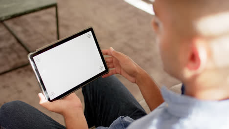 Biracial-man-making-video-call-using-tablet-with-copy-space-on-screen,-slow-motion