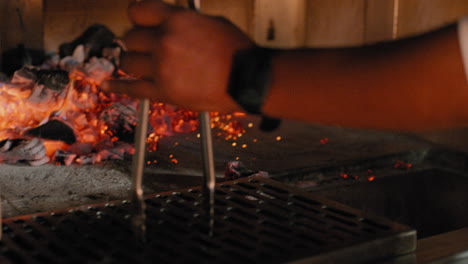 raking coals into a wood fired grill