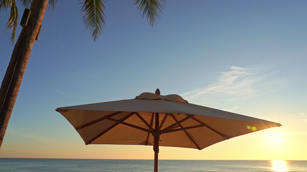 Sun Parasol on the Beach during Sunset, Low Angle Panning Right