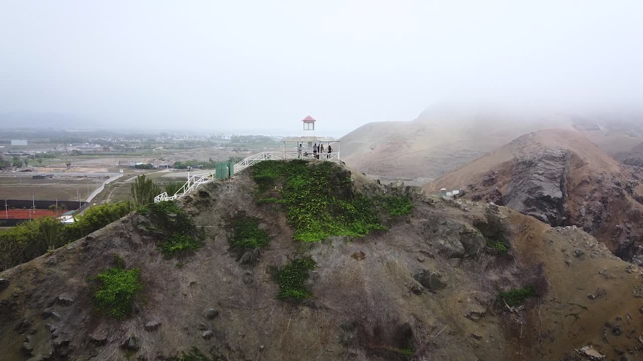 dron acercándose a un pequeño mirador en lo alto de un acantilado escarpado