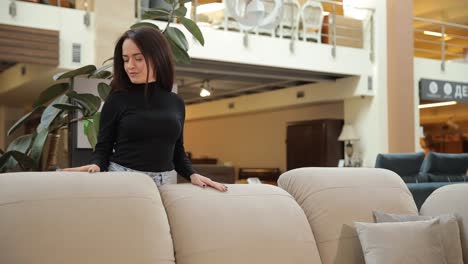 a woman is interacting gracefully with a modern sofa displayed in a chic and elegant furniture a woman is interacting gracefully with a modern sofa displayed in a chic and elegant furniture showroom space