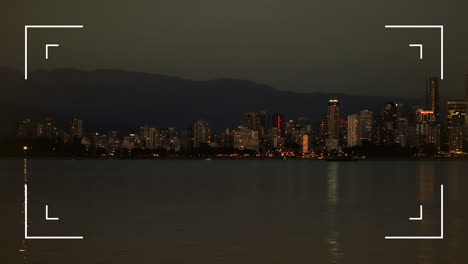 interfaz de cámara digital contra la vista del mar y el paisaje urbano por la noche