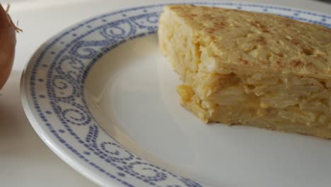 a delicious slice of spanish potato omelette, also known as tortilla, on a white plate