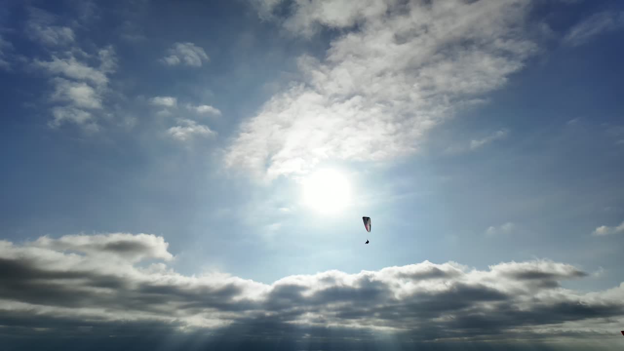 Paraglider soaring across sunny skies in Torrey Pines, San Diego, California (USA)