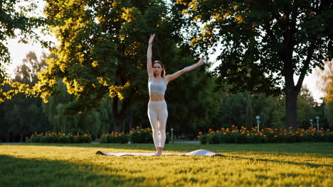 woman practicing yoga in a park at sunset