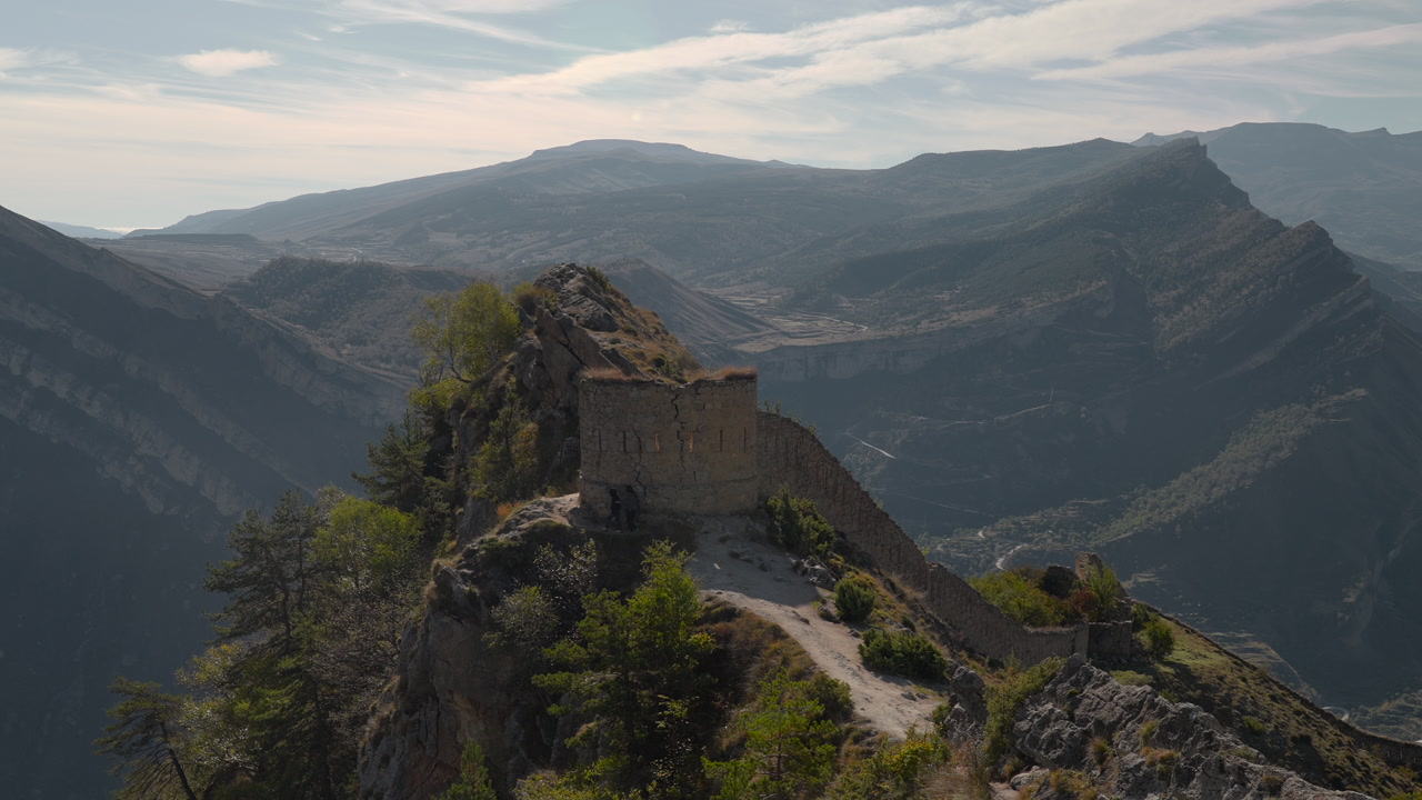 Hilltop Fortress Above Winding Valley, Narrow Trail Leads To Weathered Stone Gate, Conservationist Inspecting