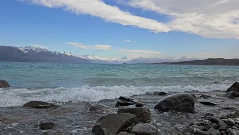 Toma-Panorámica-De-Olas-En-El-Lago-Pukaki-Rompiendo-En-La-Orilla-Rocosa