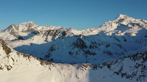 Drohnenschuss,-Der-Auf-Einen-Bergrücken-Mit-Schneebedeckten-Gipfeln-In-Der-Ferne-Zufährt