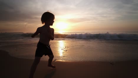 toddler playing on the beach at sunset