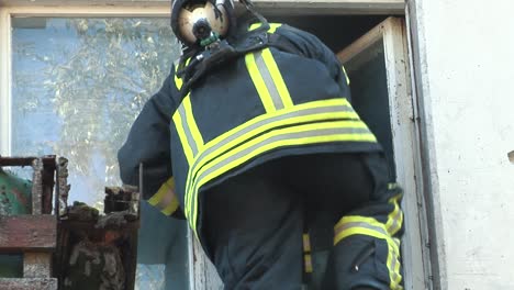 firefighter climbs up an apartment window to save people