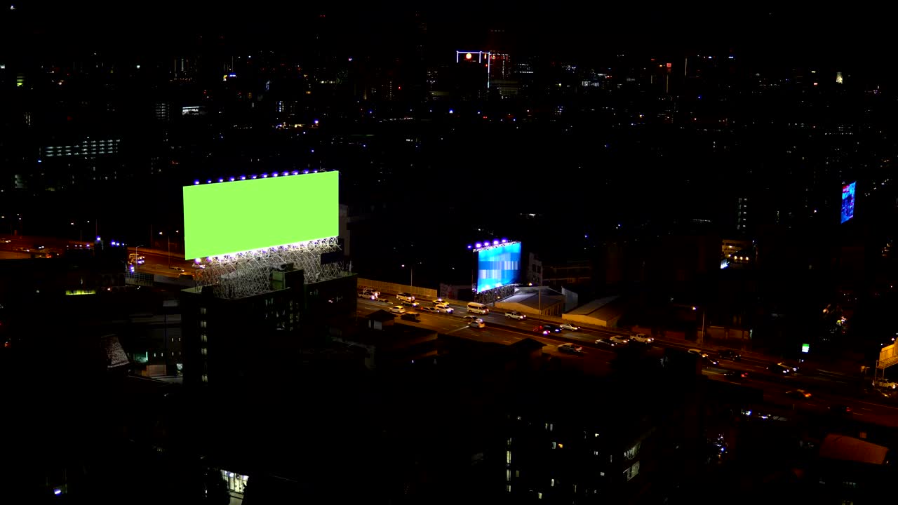 Valla publicitaria en pantalla verde con fondo de luces de tráfico nocturnas de la ciudad. Bangkok, Tailandia. Resolución 4K