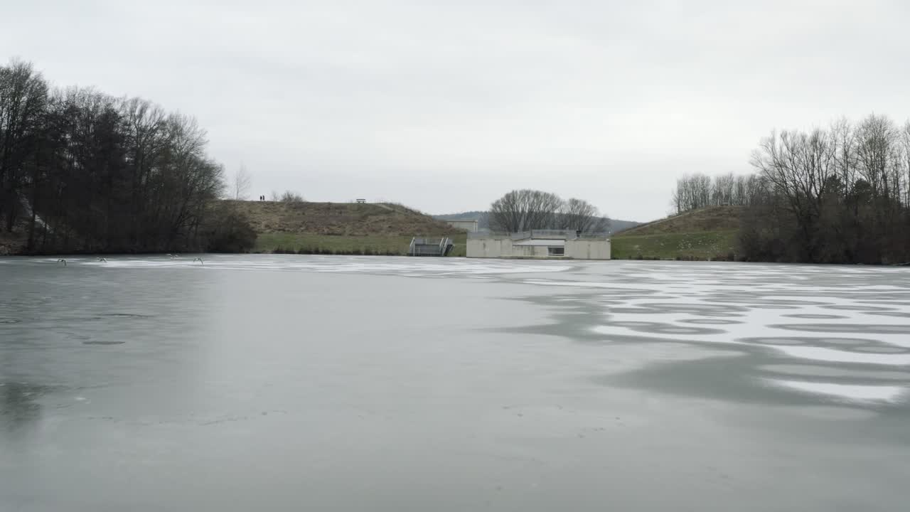 Drone aerial footage of a 4k drone flying very close over a frozen lake in Germany