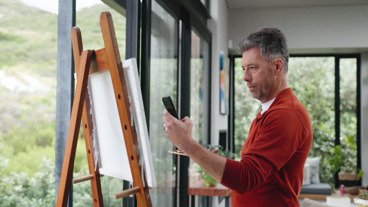 Man Painting on Easel and Taking Photo of Artwork with Phone