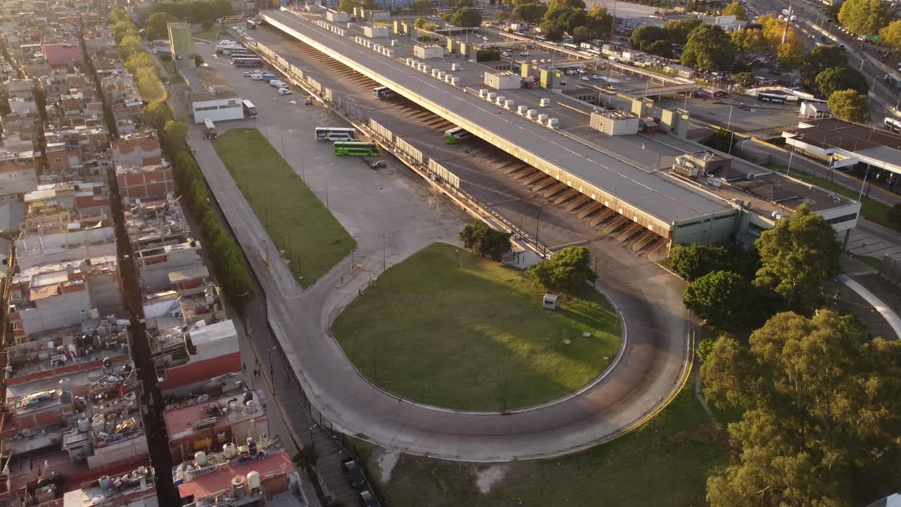 sobrevuelo aéreo que muestra autobuses en la estación de tren de retiro al lado del distrito de viviendas en la ciudad de buenos aires al atardecer