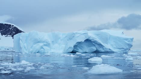 Hermosos-Icebergs-Azules-De-La-Antártida,-Iceberg-Flotando-En-El-Agua-Del-Mar-Del-Océano-De-La-Península-Antártica-En-Un-Clima-Frío-De-Invierno,-Vista-De-ángulo-Bajo-Y-Gran-Angular-Del-Paisaje-Marino-Y-Paisajístico