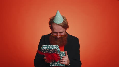 happy young man opening gift box, unwrapping birthday surprise satisfied with best present bonus