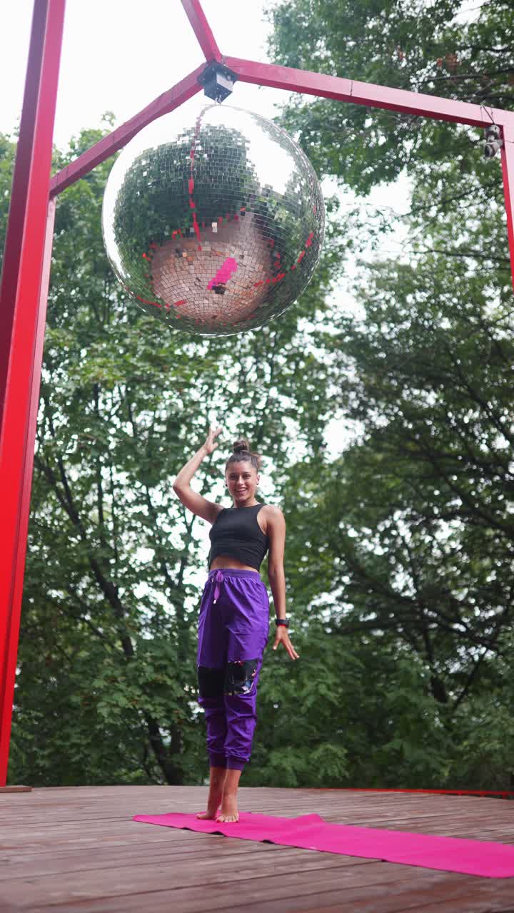 sesión de yoga al aire libre con bola de discoteca