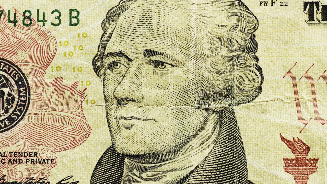 Close pan of a modern U.S. ten dollar note showing portrait and center crease
