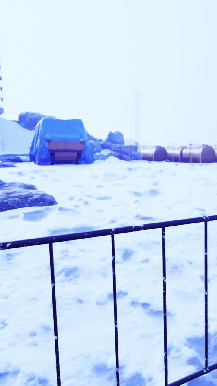 Charming winter scene with snow covered rocks and a blue tarp shelter