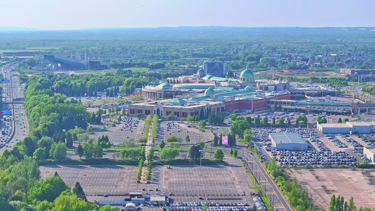 Aerial: Trafford Centre large indoor shopping centre during the day in Trafford Park, Greater Manchester, England, establishing drone shot