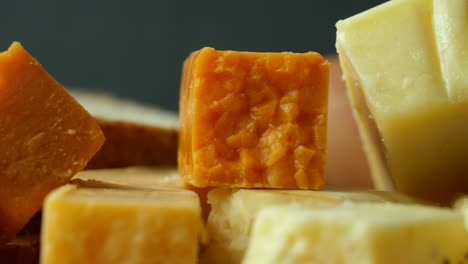 cheese cubes green, yellow and red  on chopping board