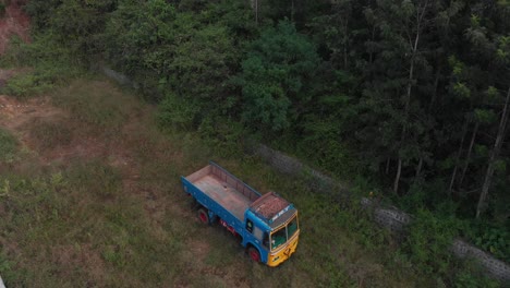 vista aérea sobre un camión de color estacionado cerca de una selva tropical en un entorno natural verde, toma amplia, concepto de conservación