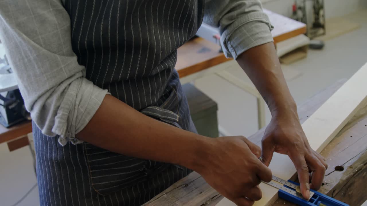 carpintero midiendo una tabla de madera con una escala de 4k
