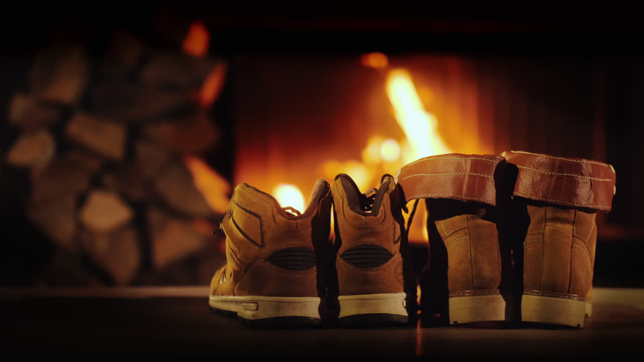 남자와 여자의 겨울 부츠는 낭만적인 겨울 저녁 벽난로 근처에서 건조