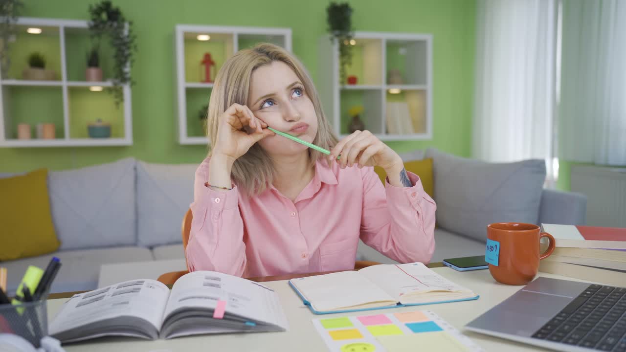 Young university girl studying at home trying to solve the question.