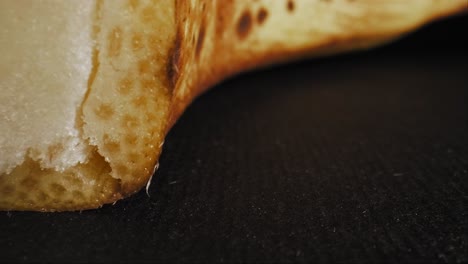 vibrant yellow ripe banana with rich brown spots, captured against a black background under studio lighting