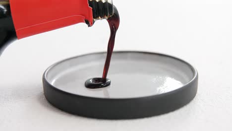 pouring soy sauce into plate on white background