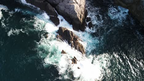 Ocean-waves-crashing-on-stones-in-the-sea-aerial-orbiting