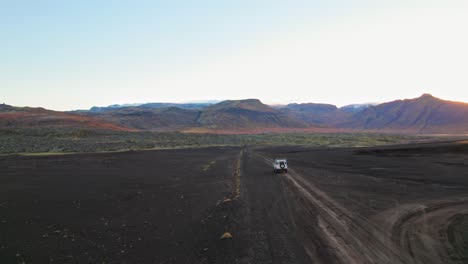 SUV-Land-Rover-Blanco-Sobre-Terreno-Volcánico-De-Arena-Negra-En-El-Campo-De-Islandia