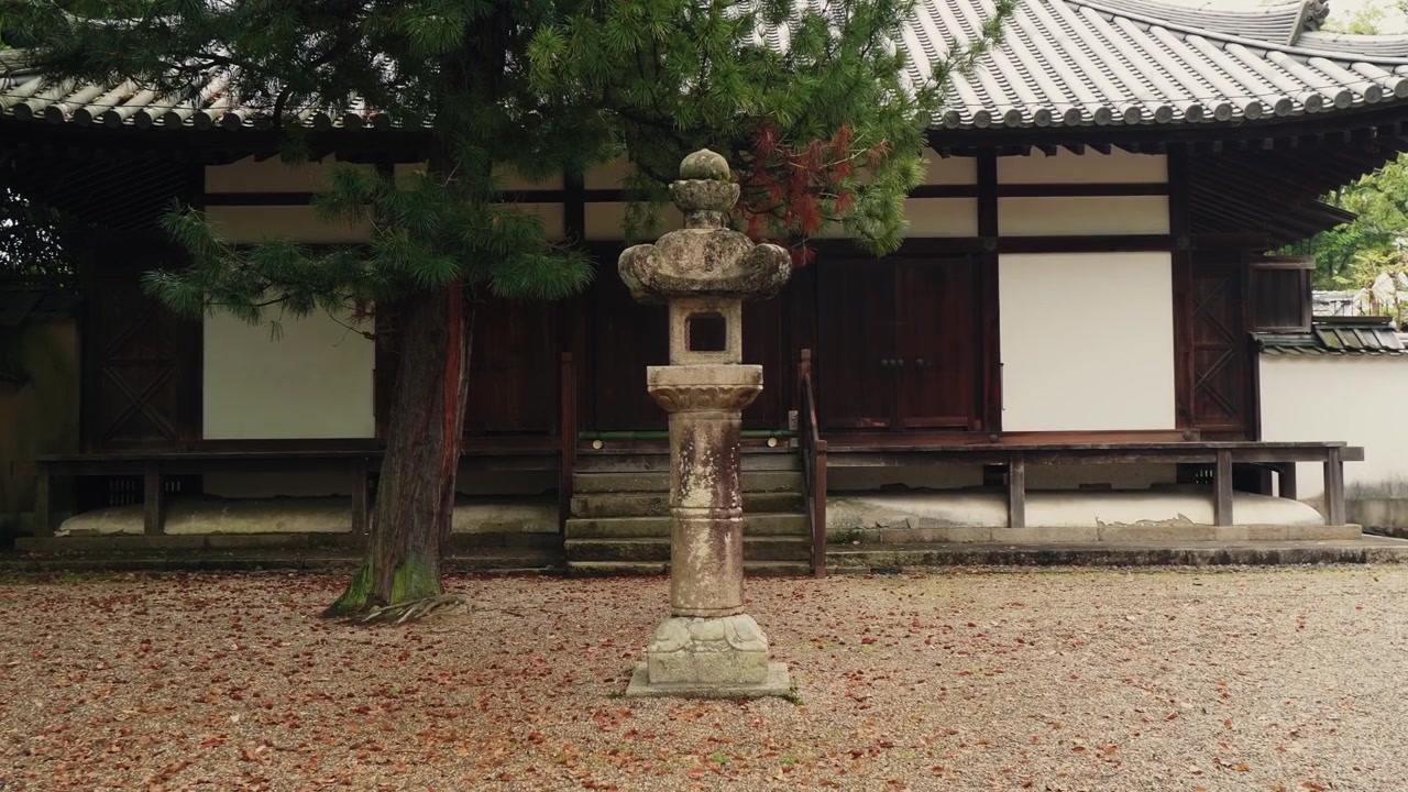 飽經風霜的石燈籠佇立於傳統日本佛寺的寧靜庭院中。