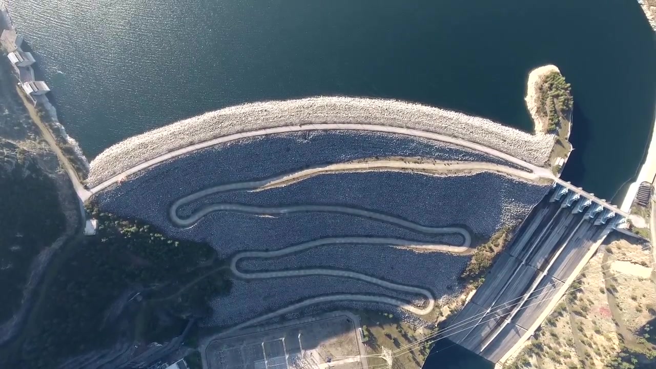 Vista aerea di una grande diga e di un bacino idrico in una valle montana