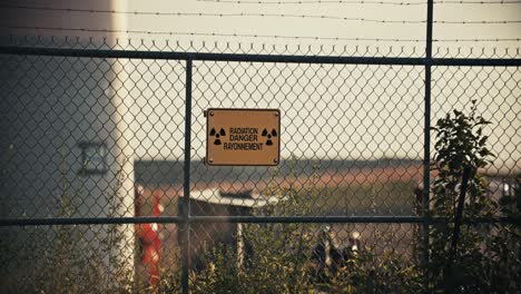 Nuclear-Radiation-Danger-Sign-on-Barbed-Wire-Perimeter-Fence-in-Exclusion-Zone-Slow-Motion-4K