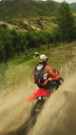 deportista monta motocicleta cruza charcos de barro fpv. motociclista en uniforme en vehículos modernos recorre el área de la ruta fuera de carretera. impresionante carreras extremas