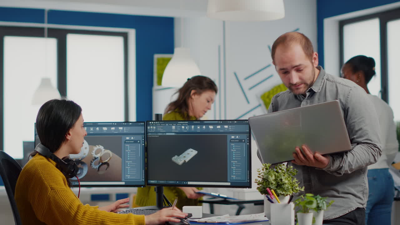 el supervisor del proyecto sostiene la computadora portátil y habla con la ingeniera