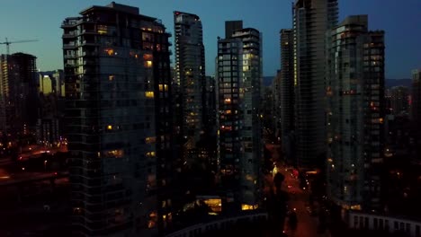 Toma-Nocturna-Aérea-De-La-Cámara-Que-Rastrea-Los-Autos-Que-Pasan-Por-El-Puente-En-Vancouver,-Canadá