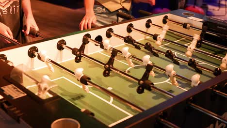 dos jugadores involucrados en un partido de futbolín