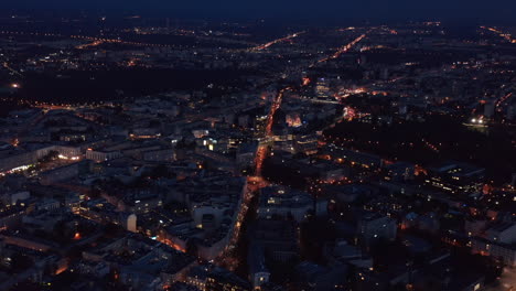 Aerial-panoramic-shot-of-night-city.-Illuminated-streets-ad-buildings-in-urban-neighbourhood.-Warsaw,-Poland