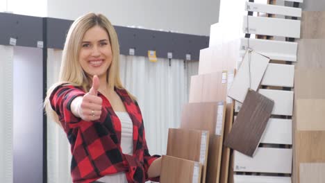 a beautiful girl seller offers laminate to customers in a building materials store