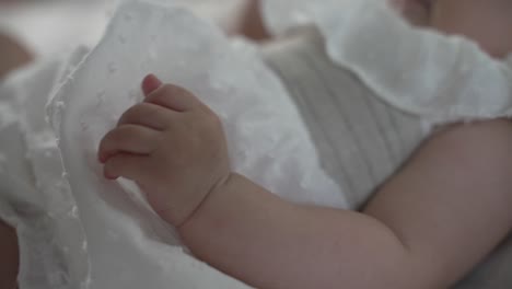 infant's hand gently resting on soft blanket